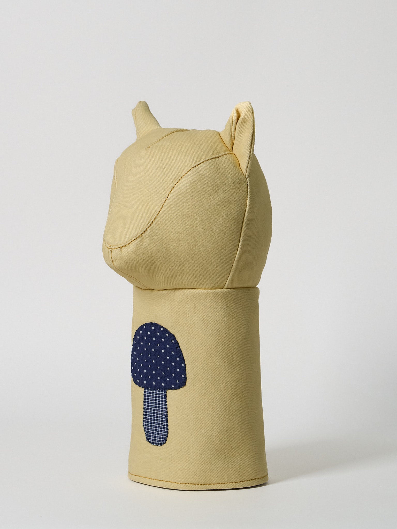 A structured golf driver headcover made from vibrant yellow denim, detailed with a playful mushroom patchwork design crafted from dark indigo denim.