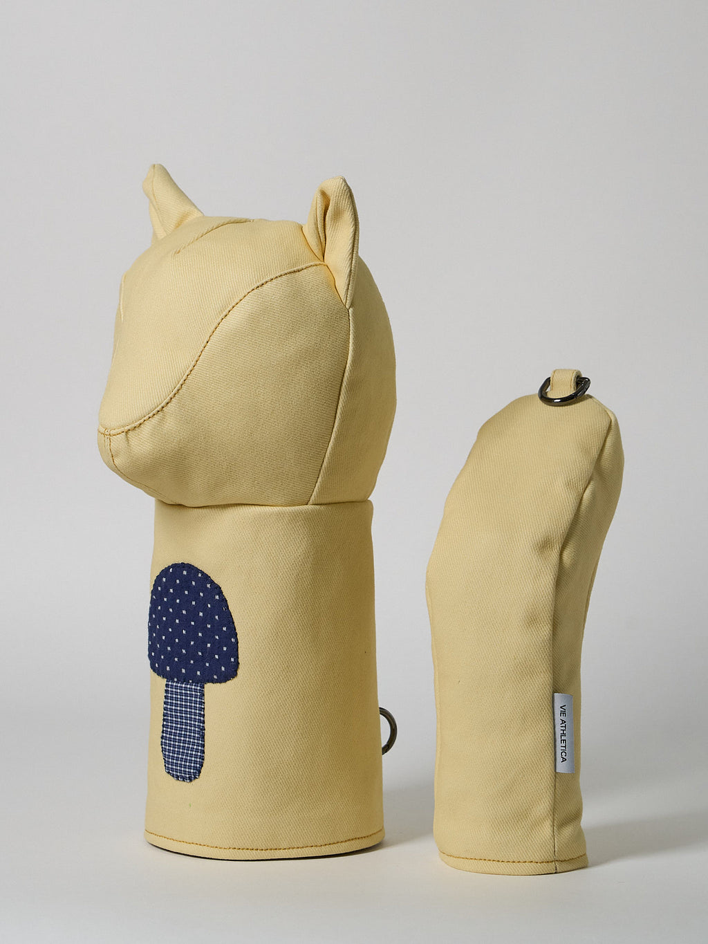A structured golf driver headcover made from vibrant yellow denim, detailed with a playful mushroom patchwork design crafted from dark indigo denim.